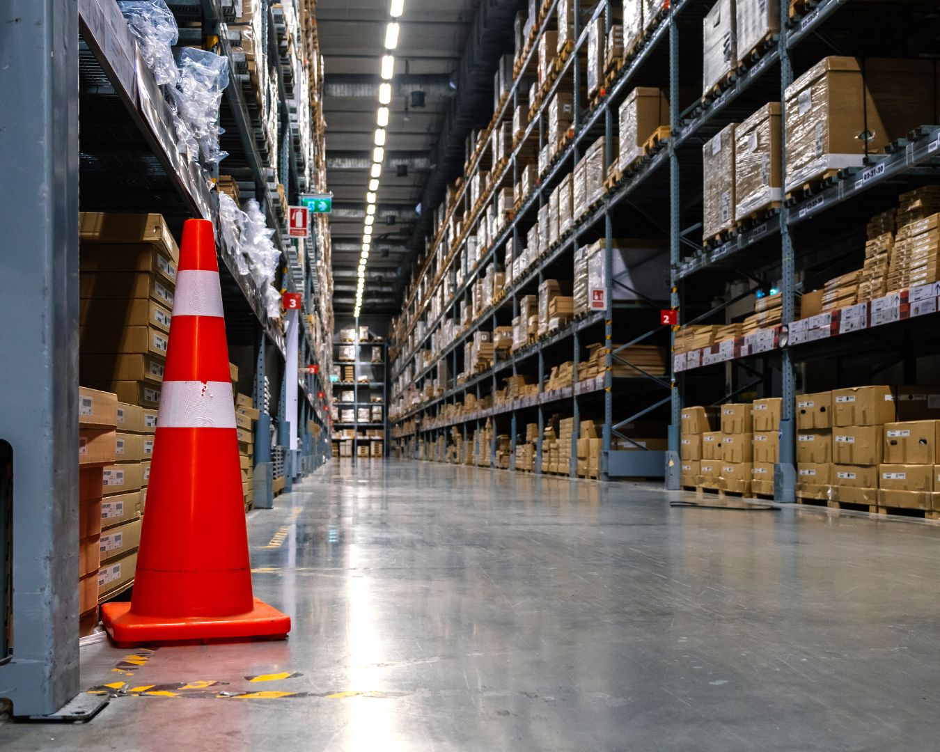 Almacén industrial moderno con cajas organizadas y un cono de seguridad, representando el entorno que impulsa el Foro Nacional de Empresas Emergentes en industria.