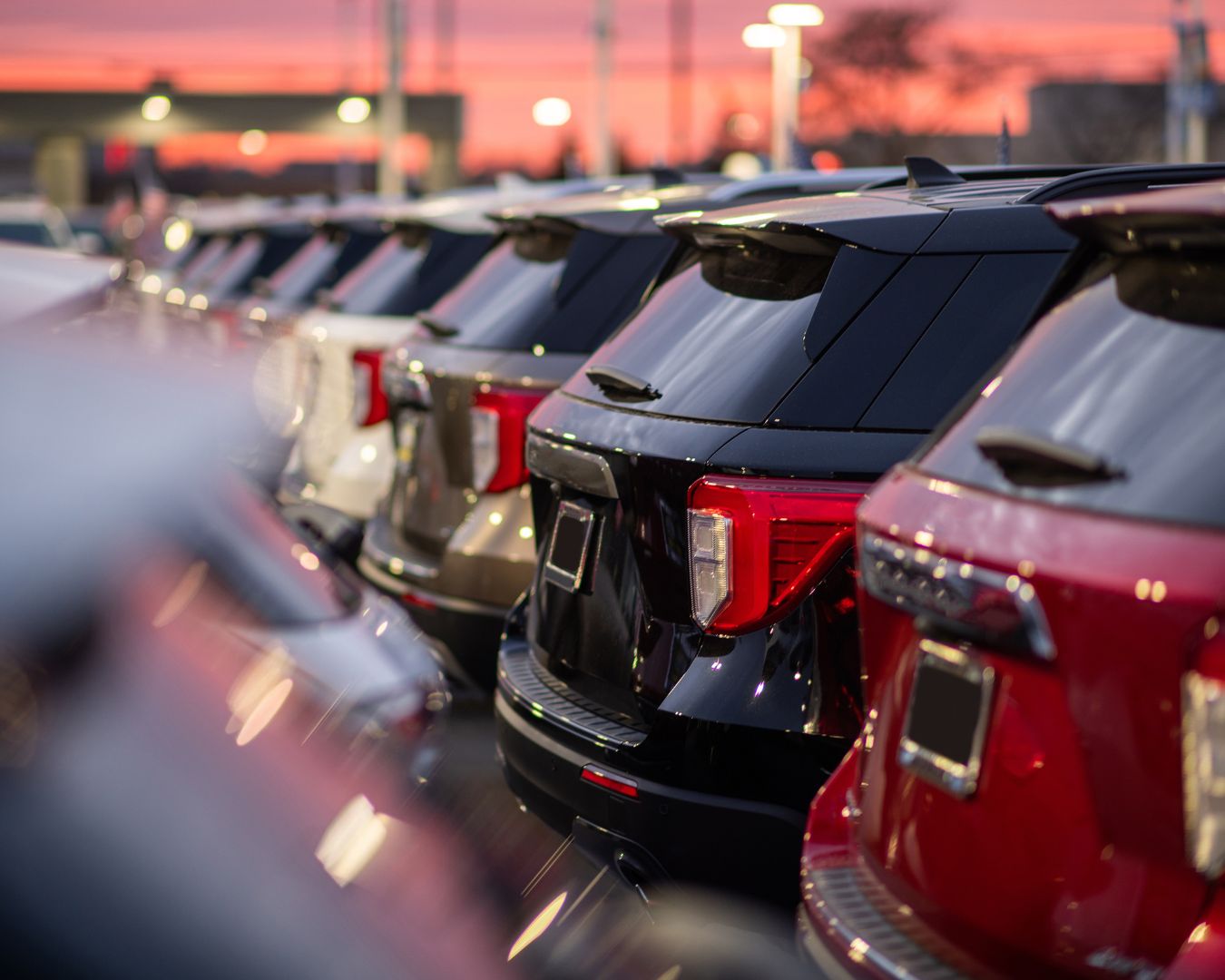 Fila de vehículos estacionados en un concesionario al atardecer, representando las pérdidas de 490 millones de euros en el sector automotriz tras la DANA.