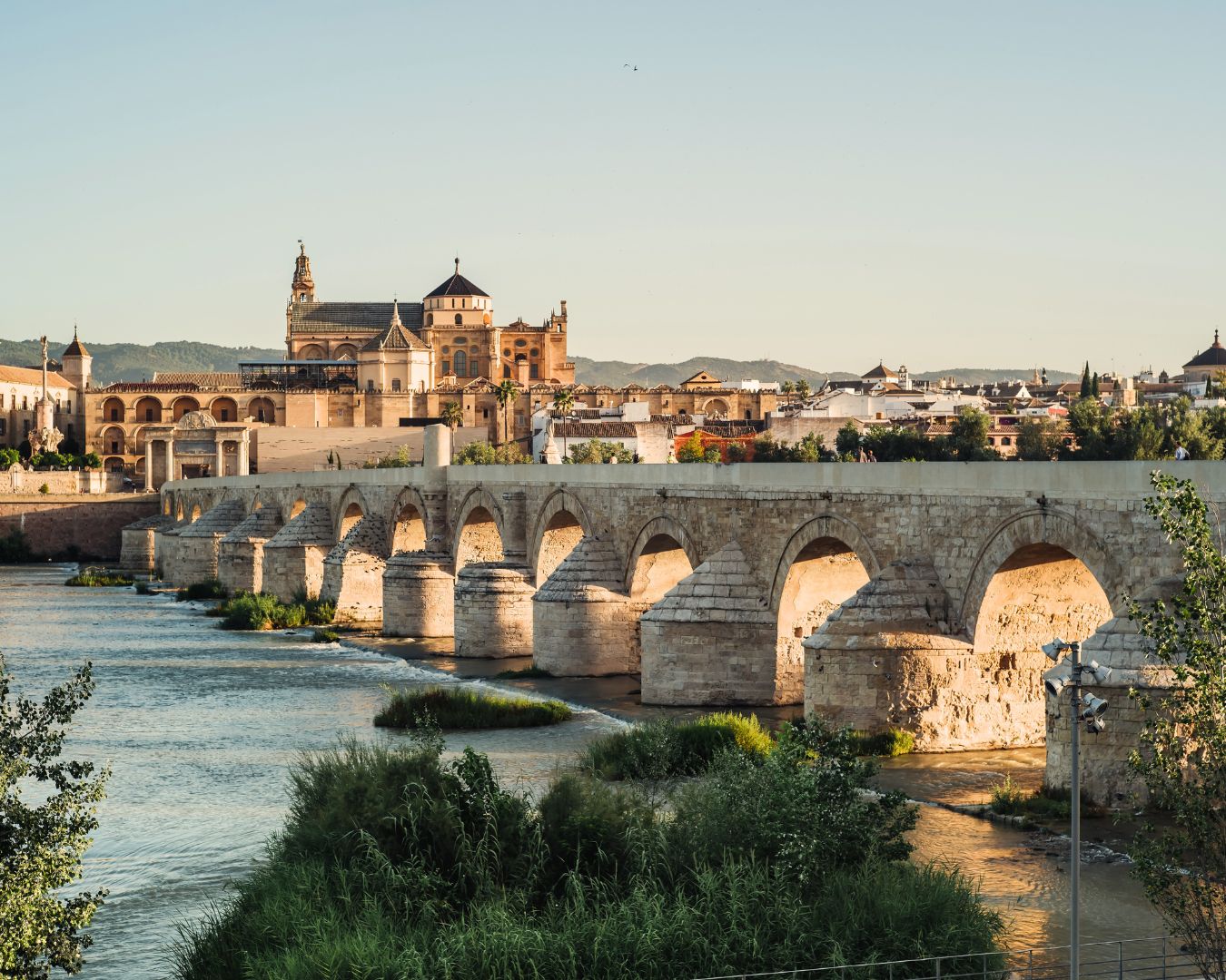 Puente romano de Córdoba al atardecer, representando el compromiso de Andalucía con la innovación y el emprendimiento, apoyado por una inversión de 108 millones de euros.