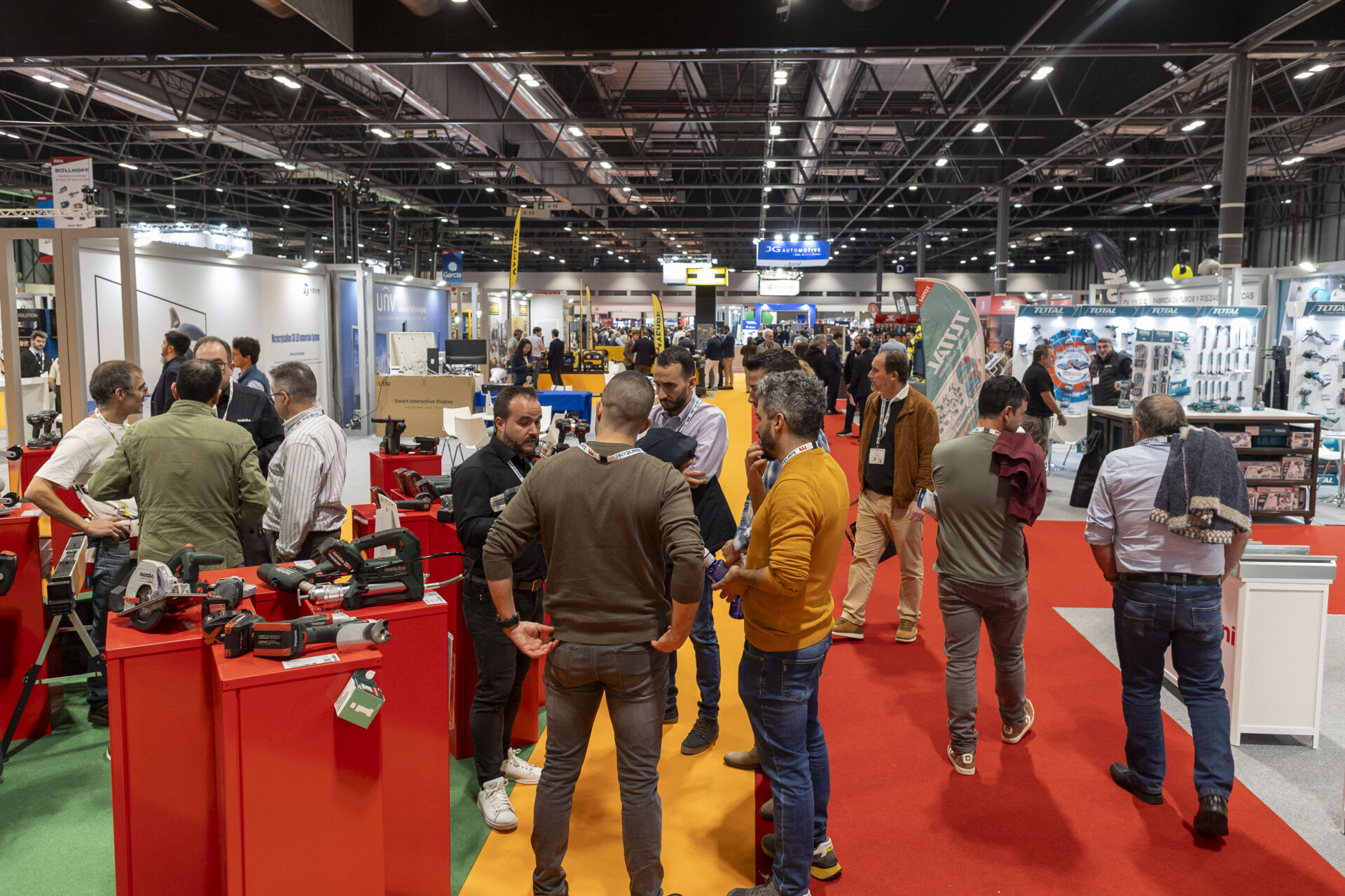 Pabellón de exposiciones de Advanced Manufacturing con celdas robóticas y maquinaria industrial avanzada en un entorno limpio.